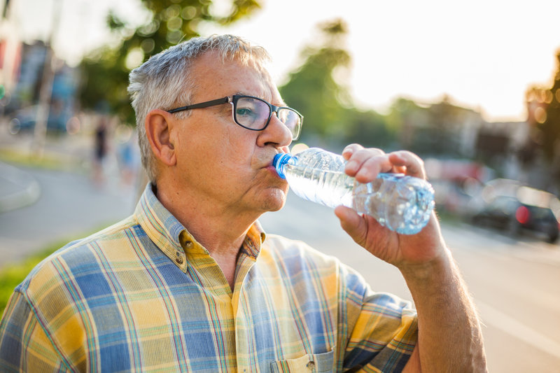 Senior man is drinking water in the city. - Get Healthy Clark County